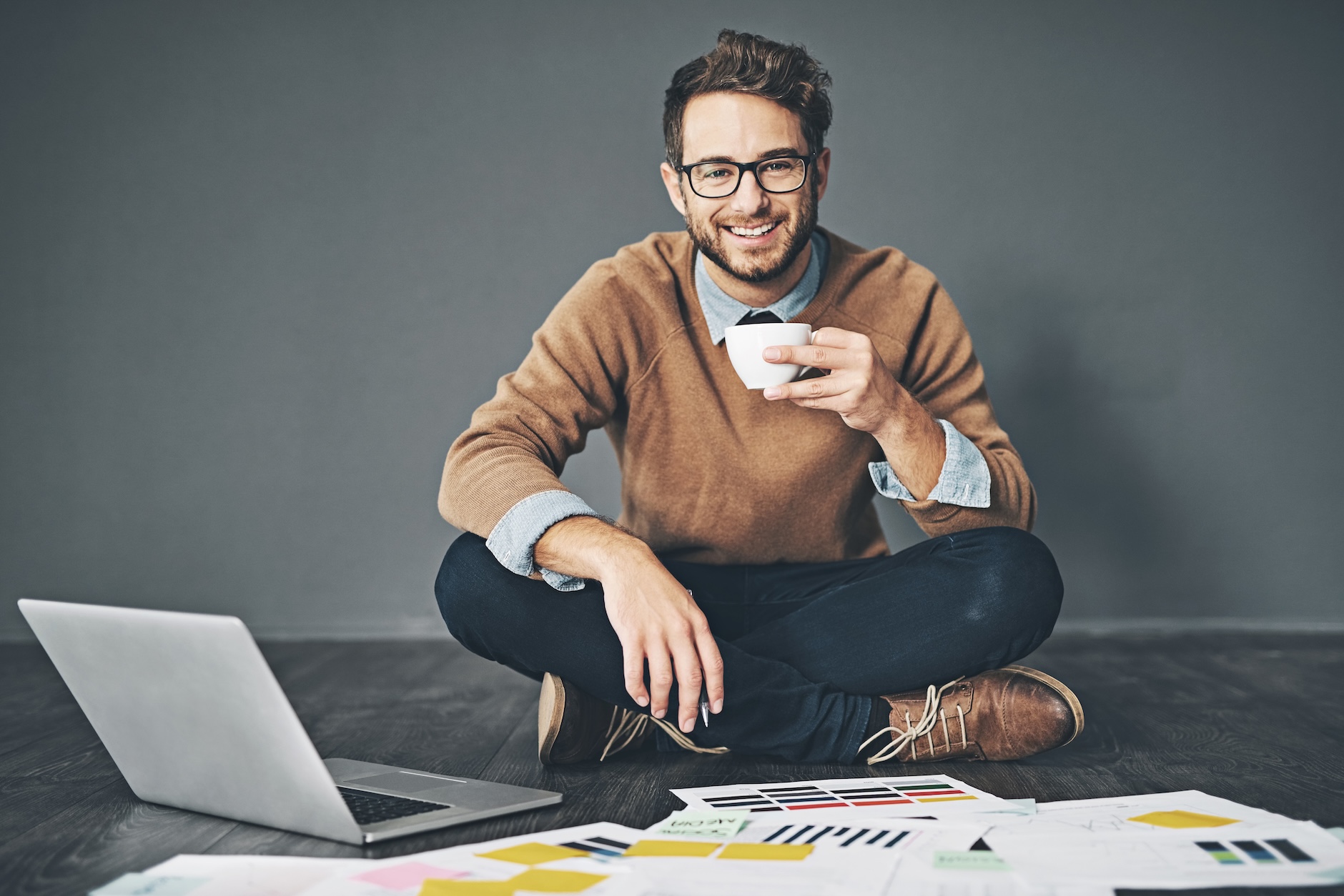 Smiling young man working at home as a solo marketer
